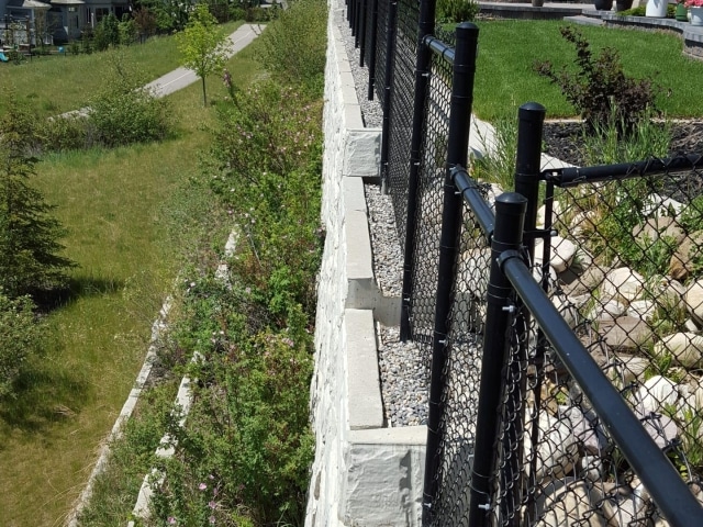 MagnumStone Retaining Wall with Fence Posts Inside the Blocks.
